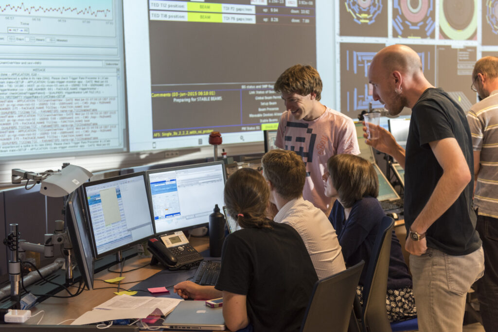 Eine Gruppe der Wissenschaftler:innen arbeitet zusammen am CERN.