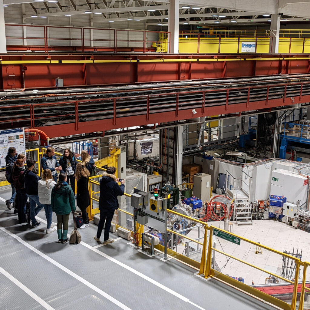 Eine Gruppe der Besucher:innen schaut sich eine Anlage am CERN an.